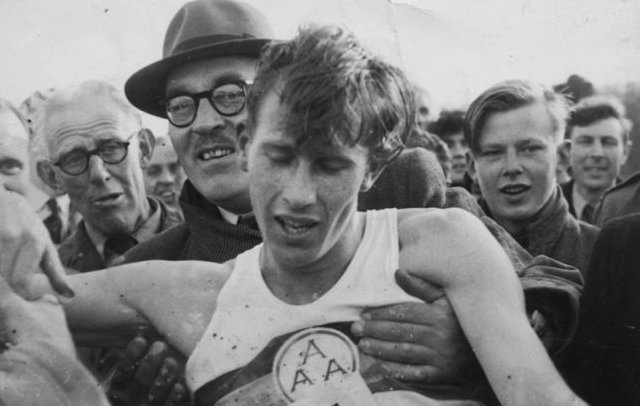 An exhausted Roger Bannister is held up by supporters