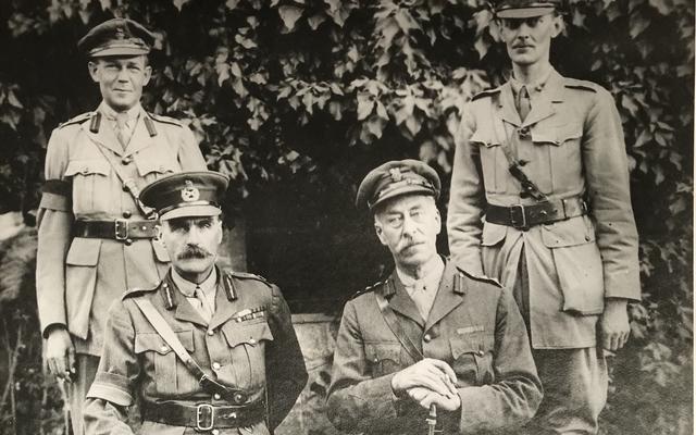 A picture of four high ranking military officials, with two seated and two standing behind them