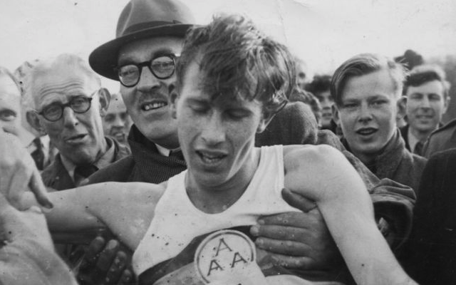An exhausted Roger Bannister is held up by supporters