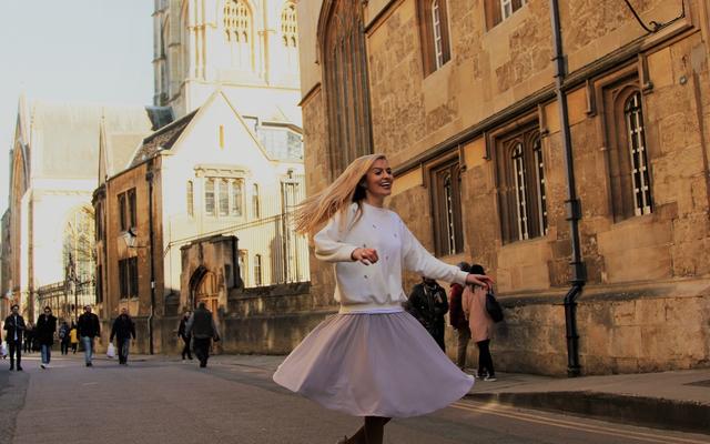 Tilly Rose spinning in a floaty skirt in the street outside Corpus Christi College