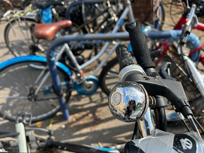 Silver bicycle bell amidst many parked bicycles at Oxford Railway Station