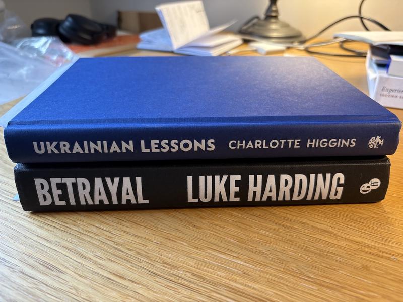 Two hardback books on their side, Betrayal by Luke Harding and Ukrainian Lessons by Charlotte Higgins