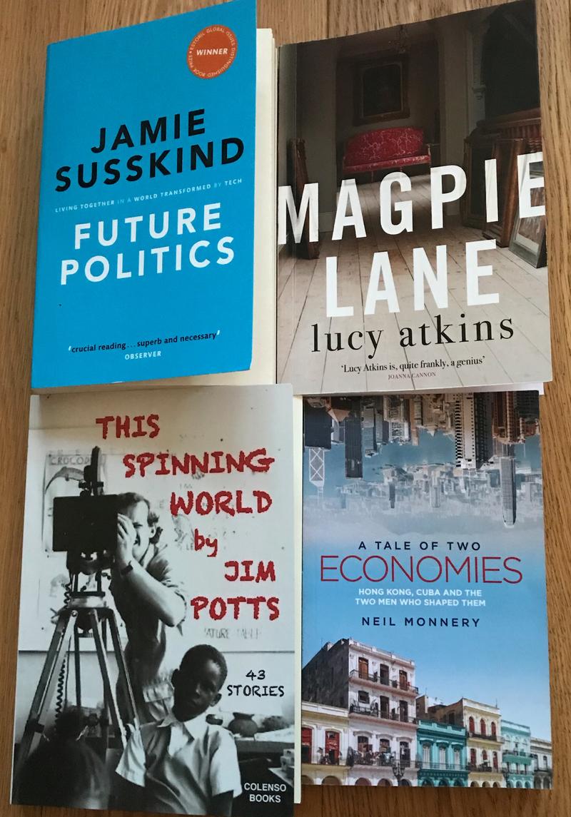 Four books on a table - 'Future Politics' by Jamie Susskind; Magpie Lane by Lucy Atkins; The Spinning World by Jim Potts; A tale of two economies by Neil Monnery