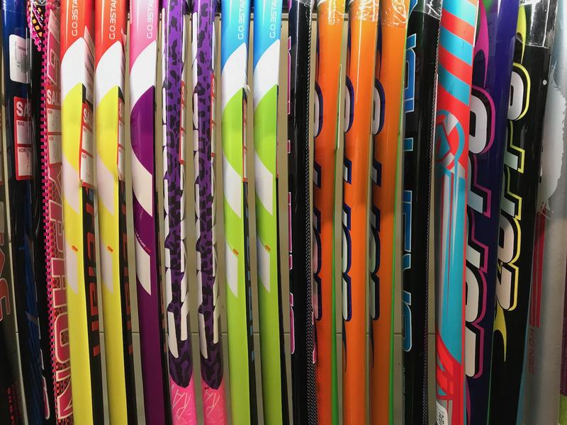 A row of multi-coloured hockey sticks