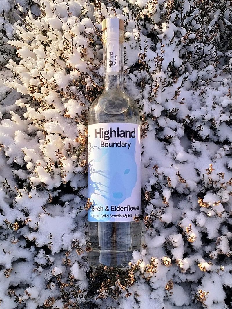 A bottle of Highland Boundary lying on snow covered heather