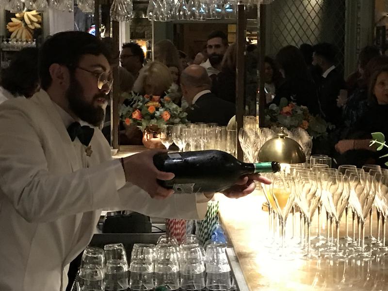 A barman, pouring glasses of wine