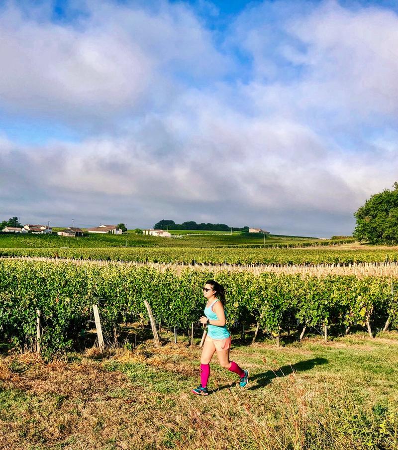 Katie Myint running passed a vineyard