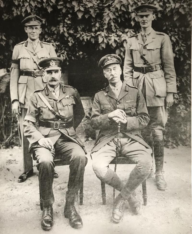 A picture of four high ranking military officials, with two seated and two standing behind them