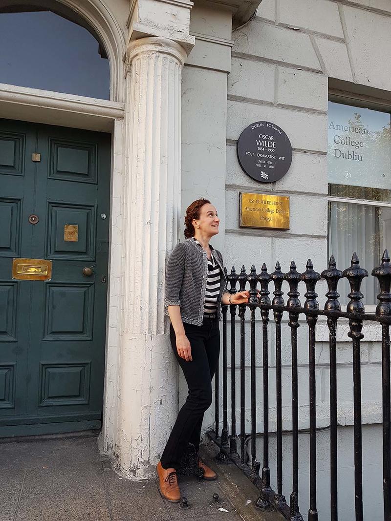 Michèle Mendelssohn stood outside a house which has a heritage plaque on it donoting it as Oscar Wilde's family home