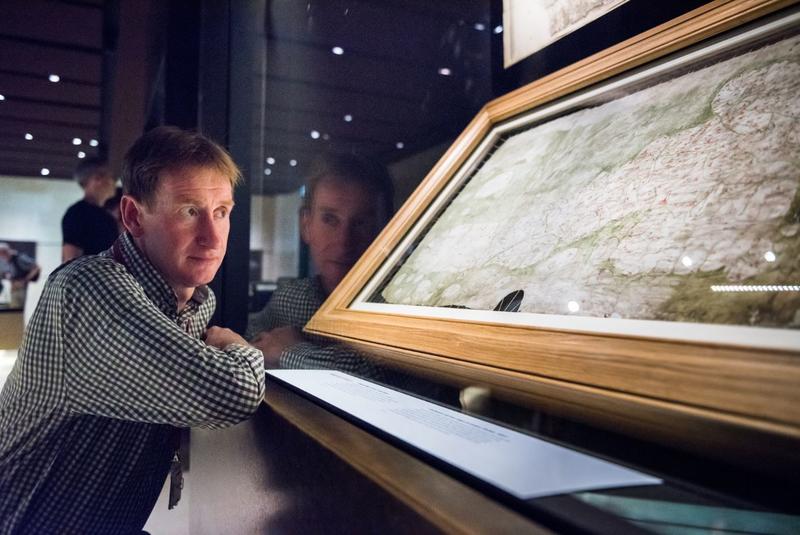 Nick Millea looking at a map which is mounted within a glass  case in a museum