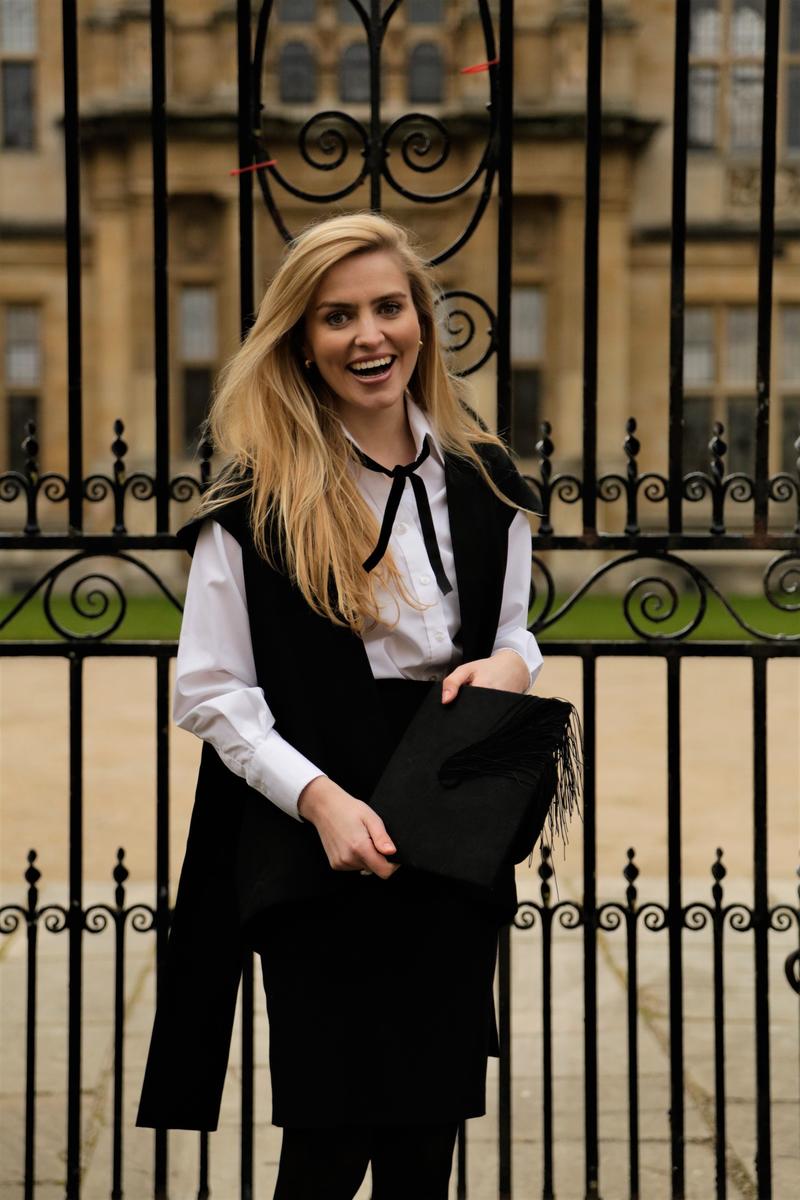 Tilly Rose, wearing sub fusc, outside the Examination Schools in Oxford