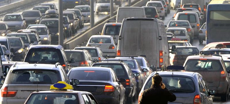 A traffic jam on both carraigeways of a motorway, with the air, and some cars, looking dirty
