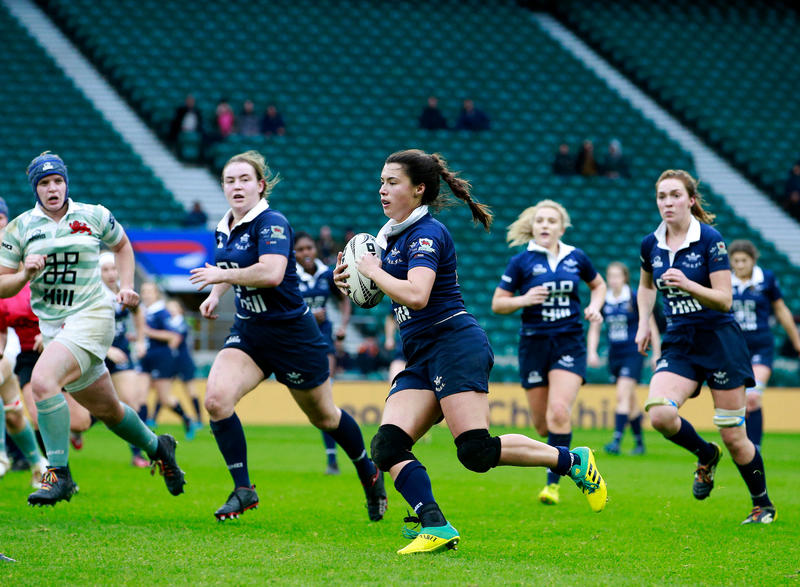 Sophie Trott, playing for Oxford in the Varsity Match, running with the ball, with team mates in support