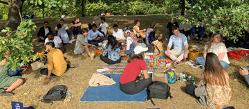 Students sat under trees having a picnic